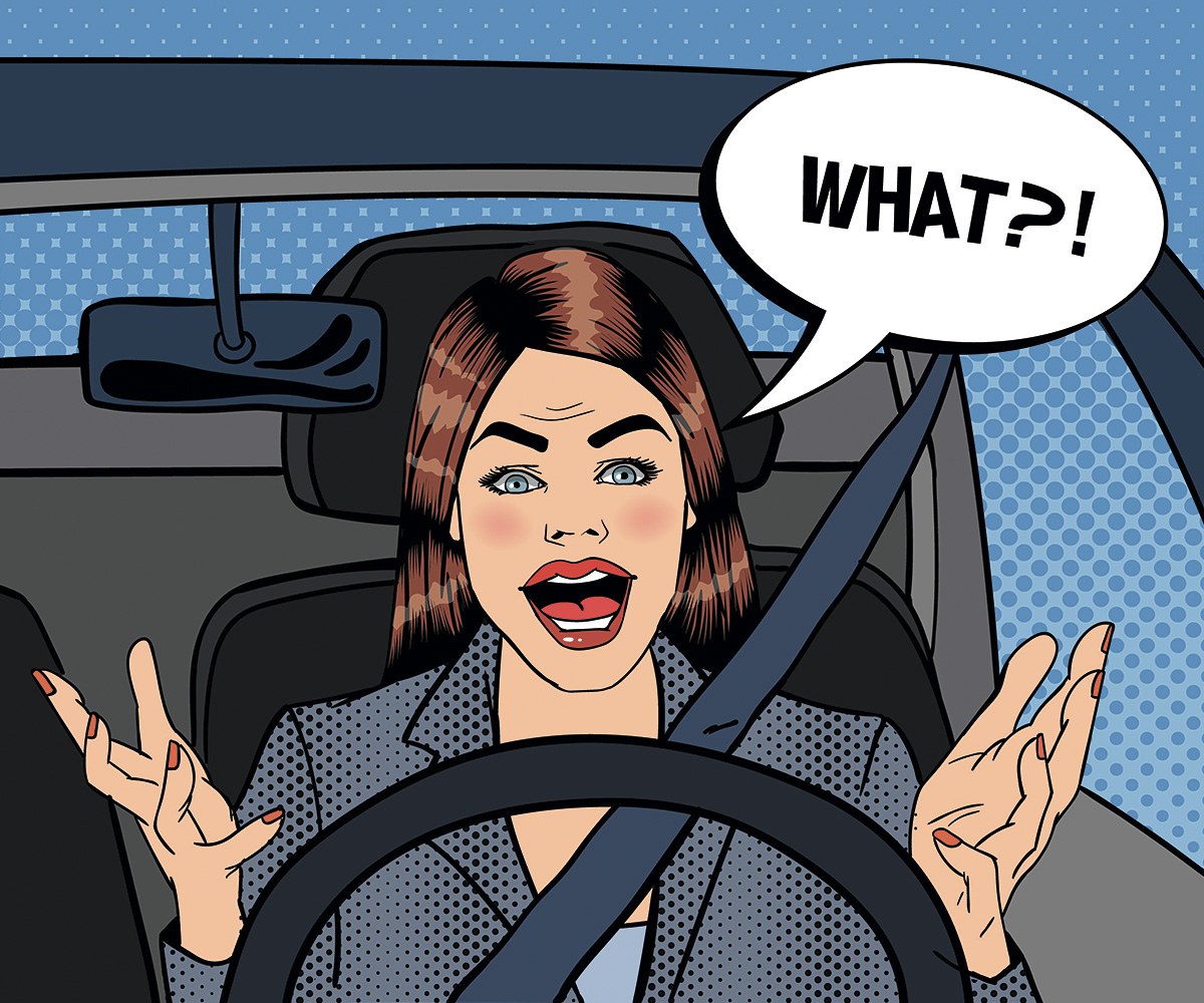 Picture of an amazed woman driving a car